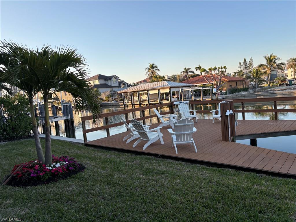 Dock featuring a water view, a yard, and a residential view