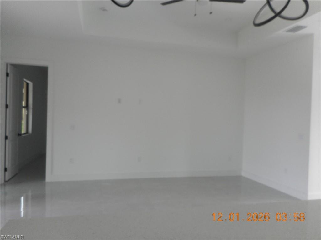 Unfurnished room featuring a ceiling fan and baseboards