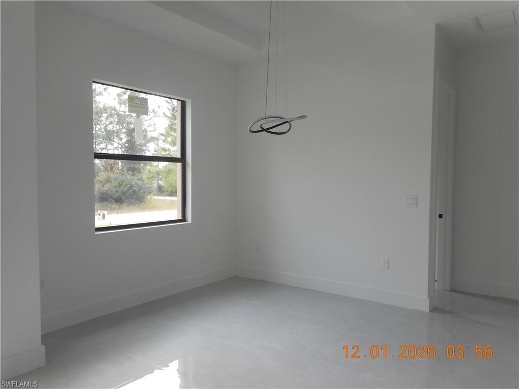 Unfurnished dining area with concrete floors and baseboards