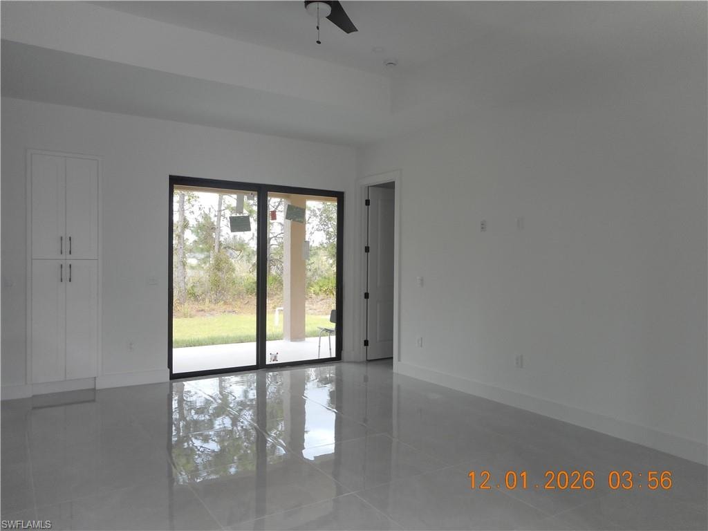 Empty room featuring baseboards and a ceiling fan