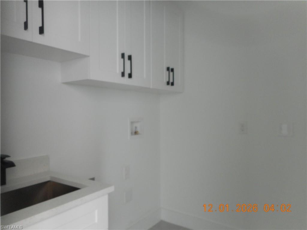 Laundry area with washer hookup and cabinet space