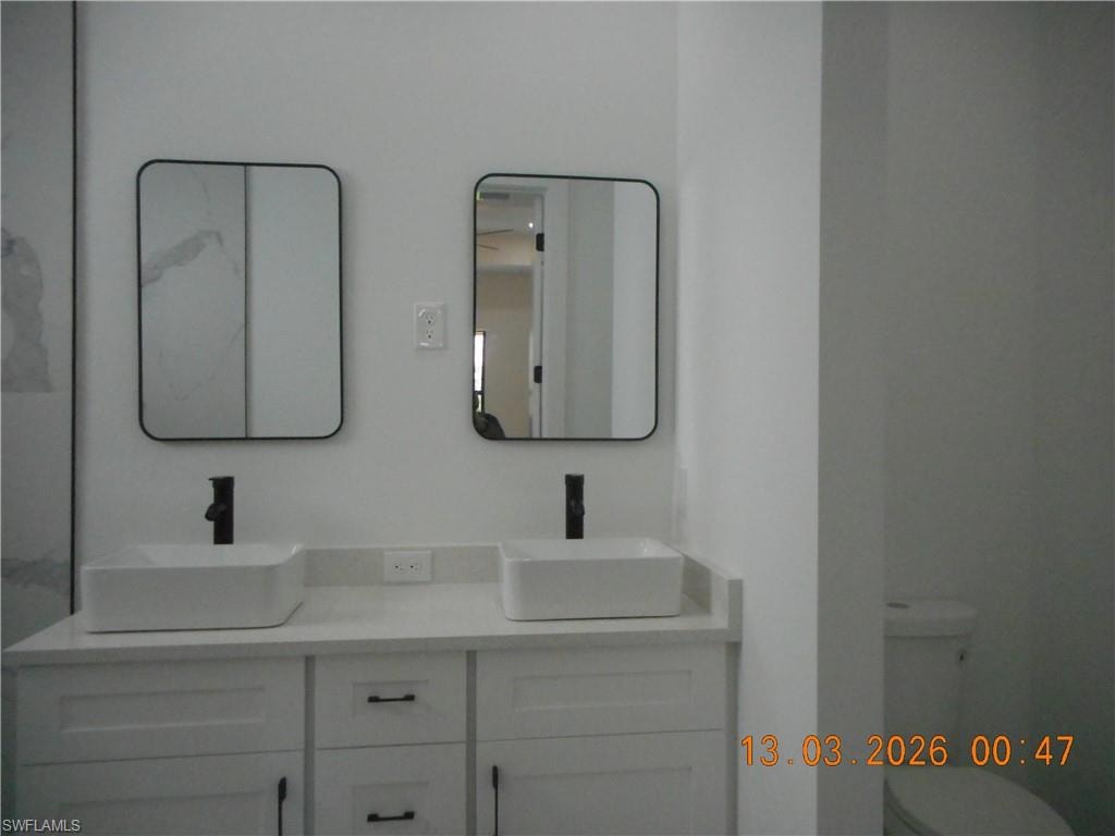 Bathroom featuring double vanity and toilet