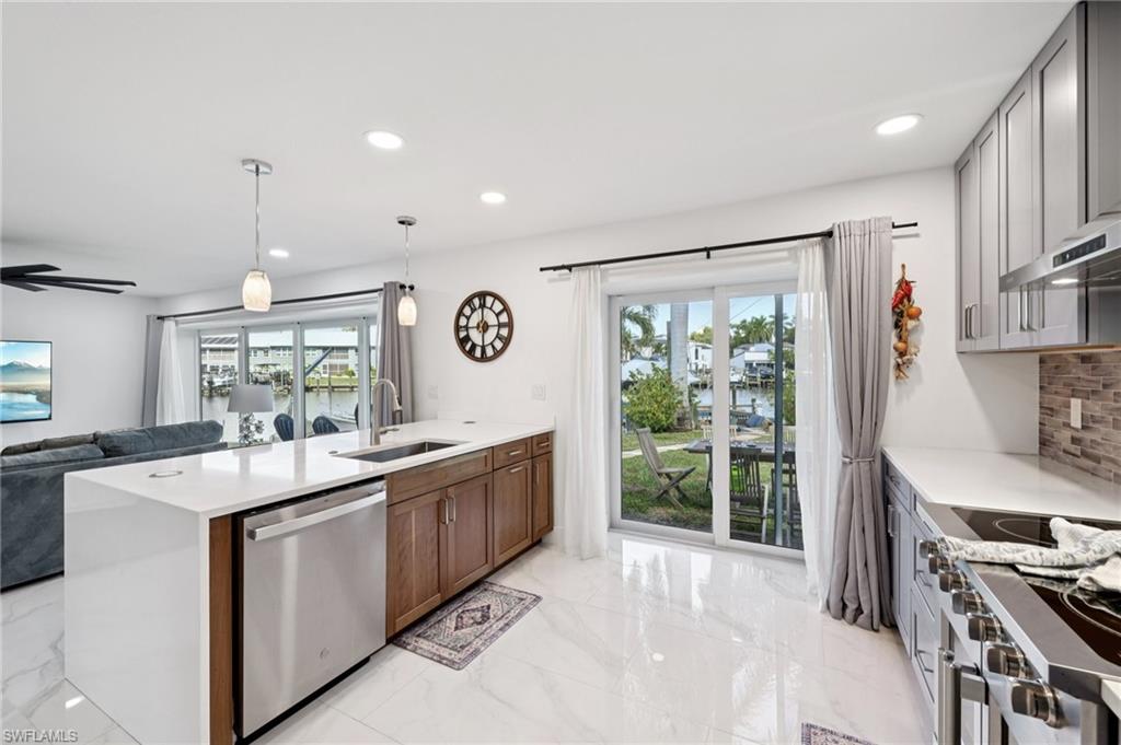 Kitchen with a water view, recessed lighting, a peninsula, open floor plan, and stainless steel appliances