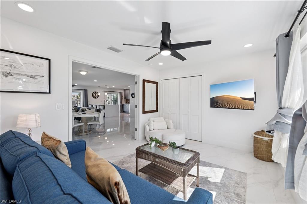 Living room with marble tiled floors, recessed lighting, and ceiling fan