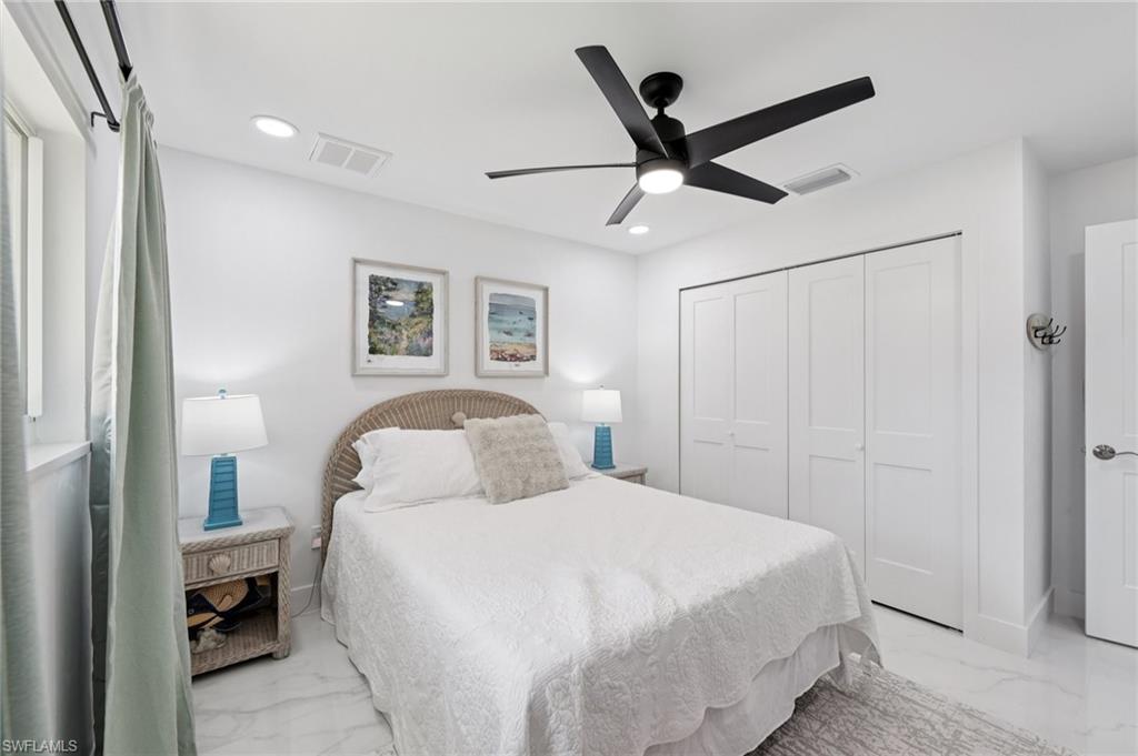 Bedroom featuring marble finish flooring, ceiling fan, a closet, and recessed lighting