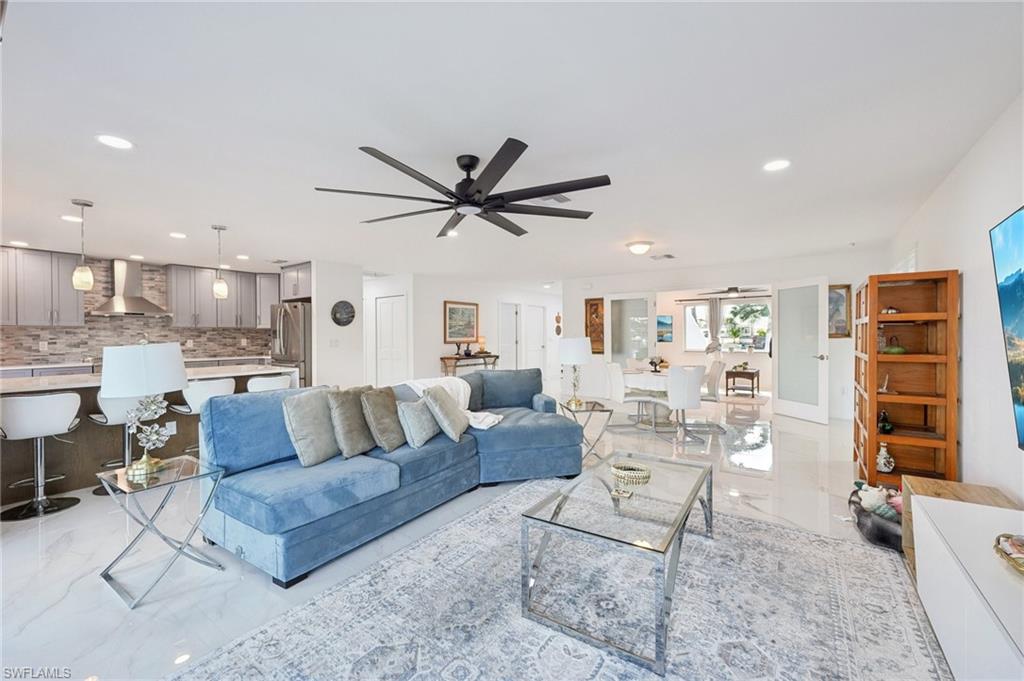 Living area with light marble finish floors, recessed lighting, and a ceiling fan