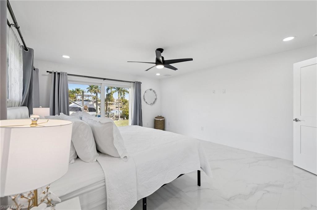 Bedroom featuring marble finish floors, ceiling fan, and recessed lighting