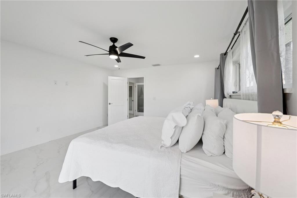Bedroom with recessed lighting, ceiling fan, and marble look tile flooring