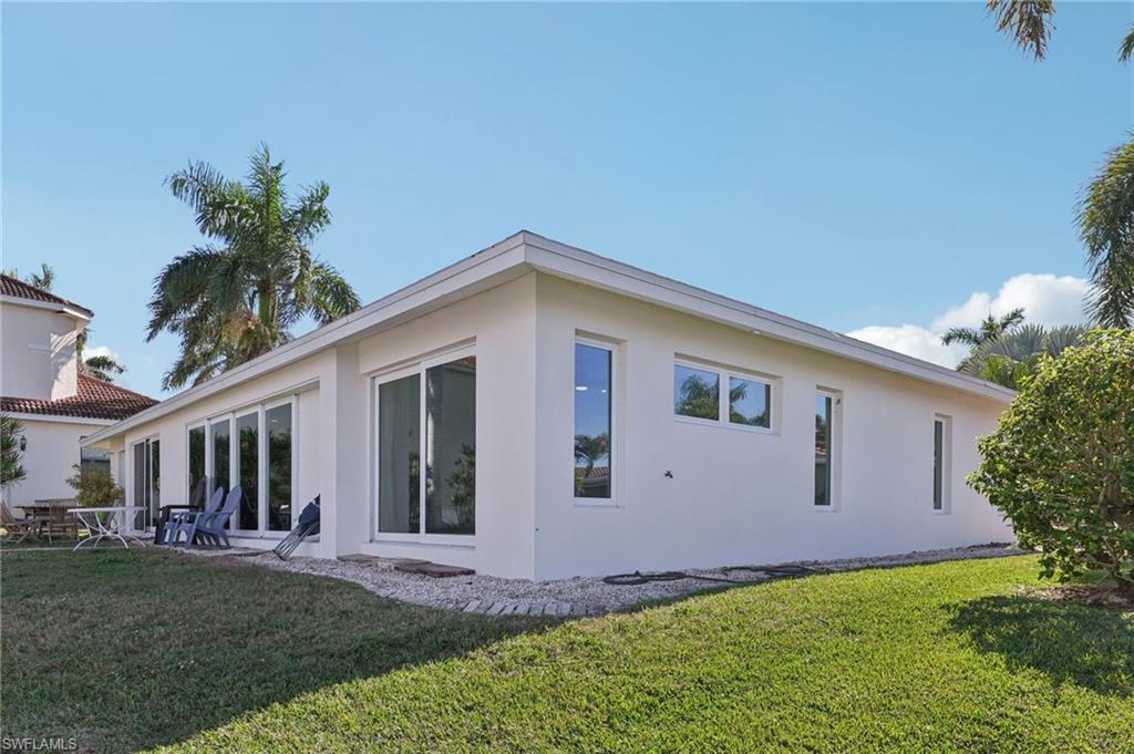Back of property with a lawn, stucco siding, and a patio