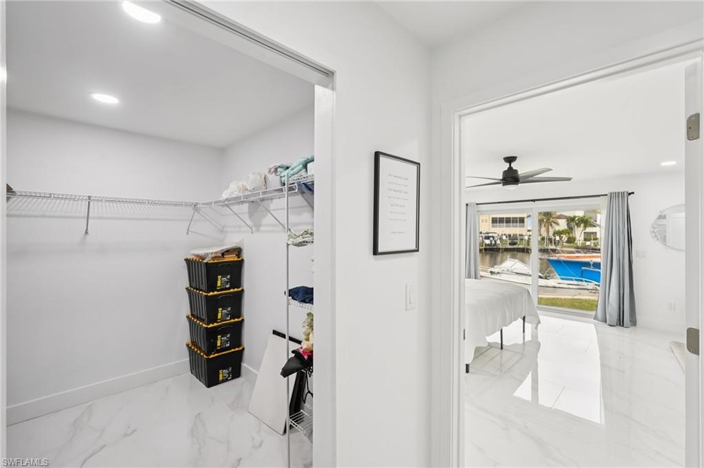 Spacious closet featuring light marble finish flooring and ceiling fan