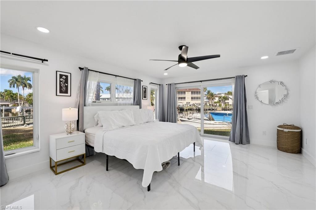 Bedroom with light marble finish flooring, access to exterior, ceiling fan, and recessed lighting