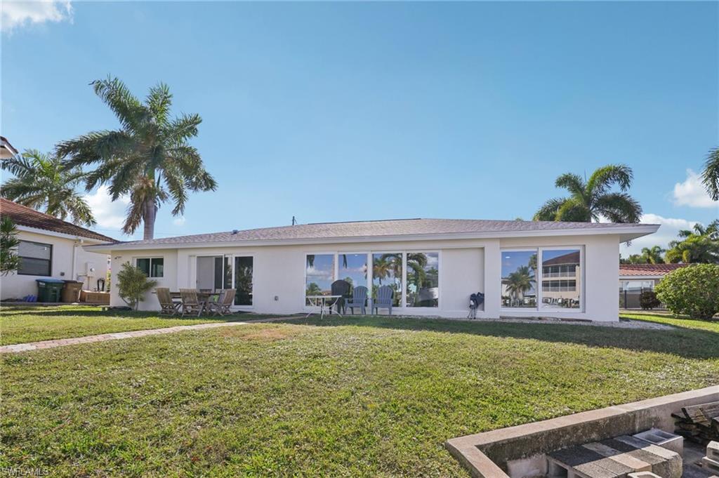 View of front of home with a front yard, stucco siding, and a patio area