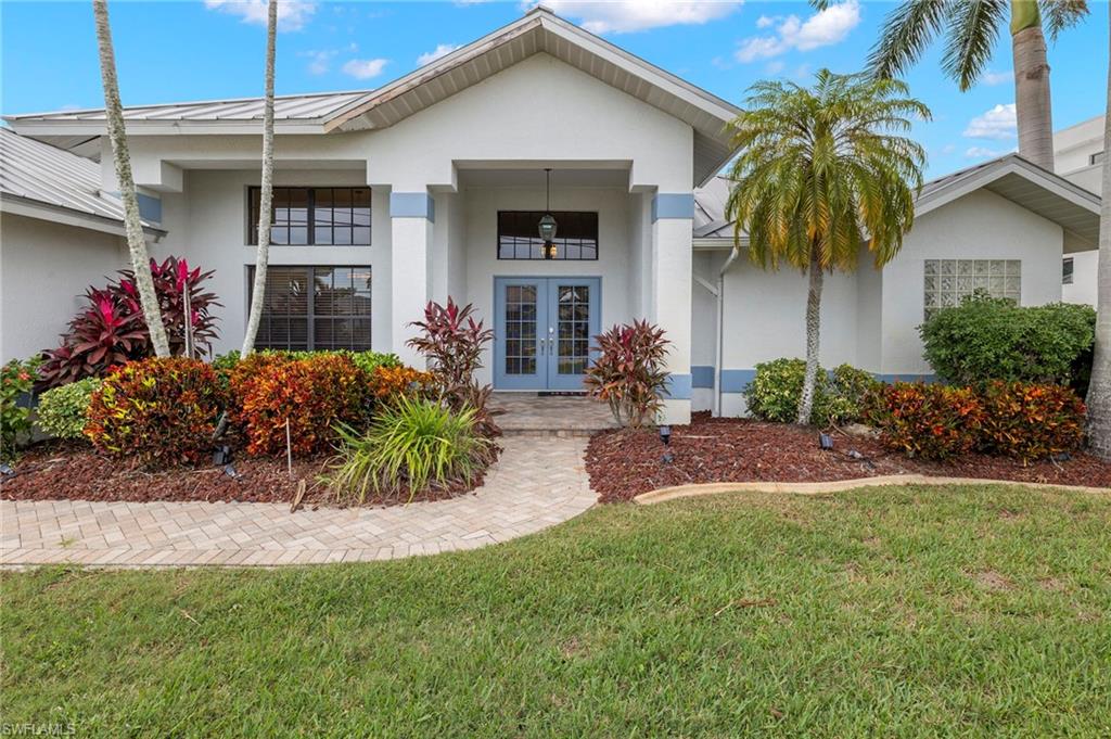 View of front of property featuring a front yard and french doors