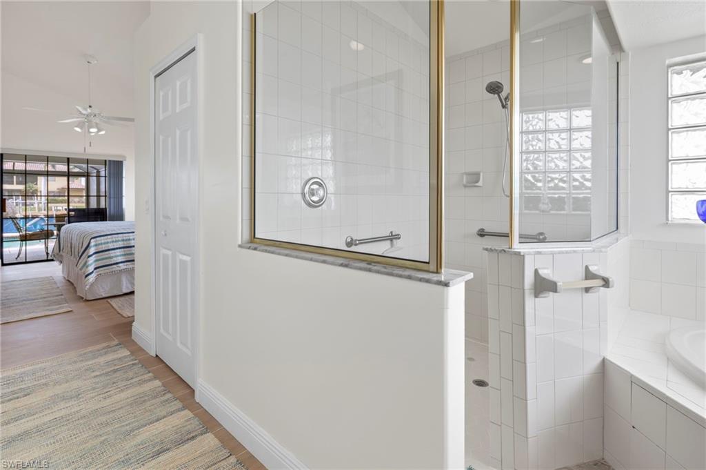 Bathroom with wood-type flooring, separate shower and tub, and plenty of natural light