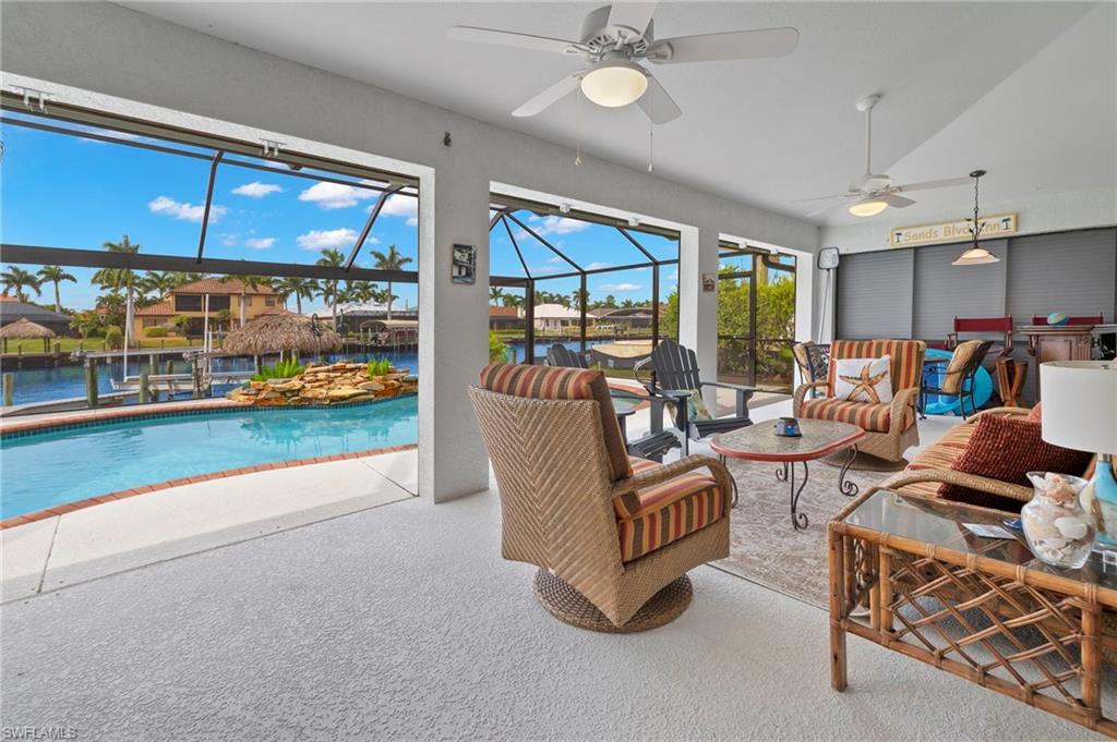 Carpeted living room featuring vaulted ceiling, a water view, a healthy amount of sunlight, and ceiling fan