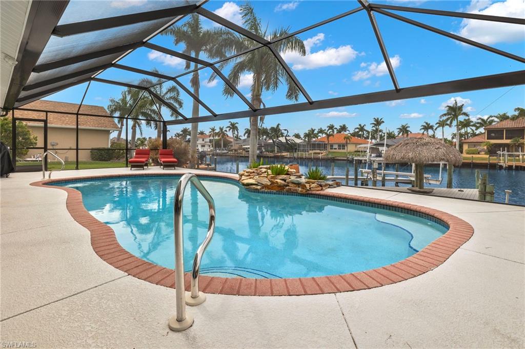 View of pool featuring a lanai, a water view, a boat dock, and a patio