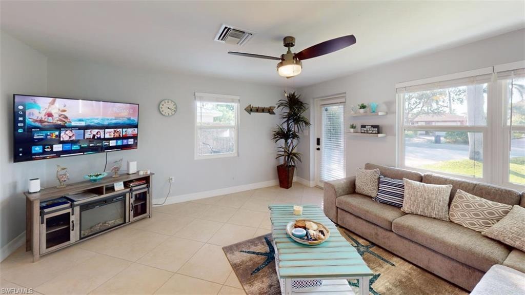 Living area with ceiling fan and light tile patterned floors