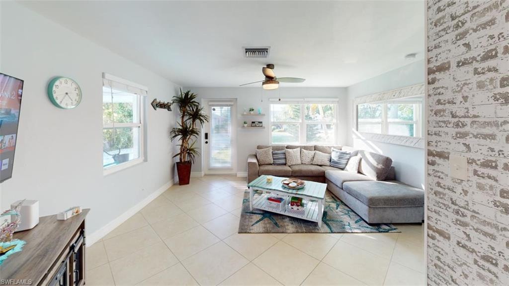 Living area with a ceiling fan and light tile patterned floors