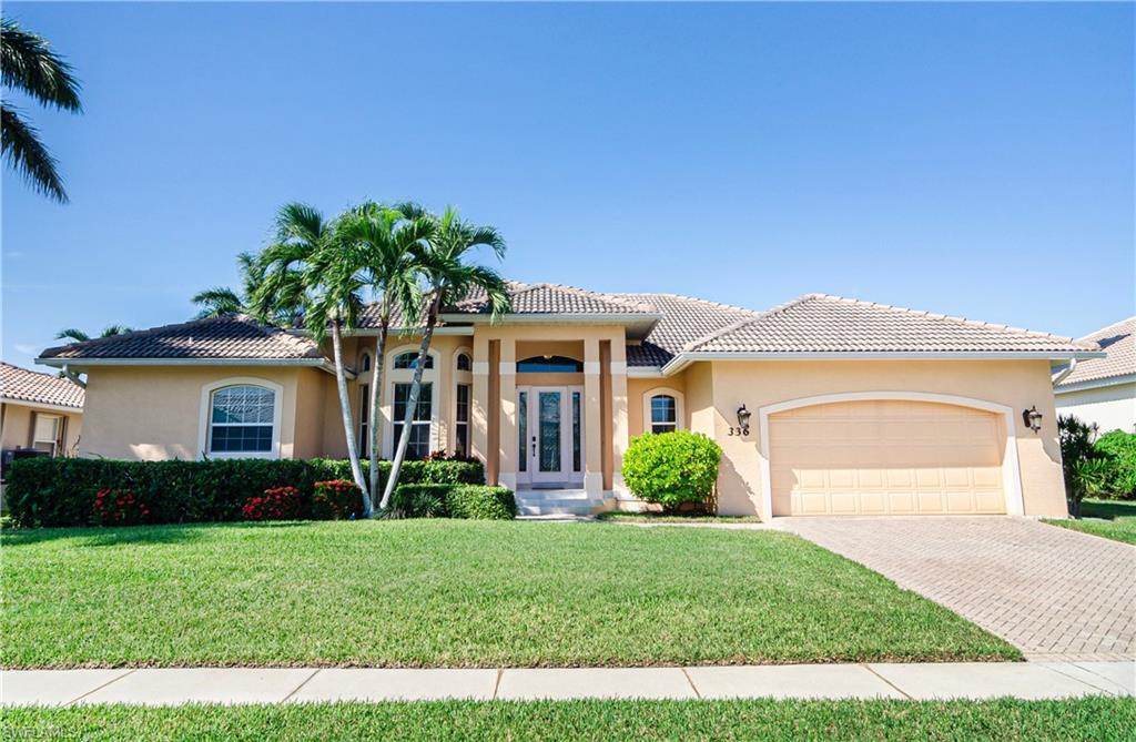 Mediterranean / spanish home featuring a garage, a front lawn, and french doors