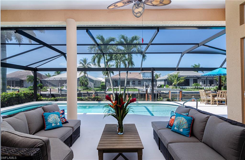 View of swimming pool featuring an outdoor living space, a lanai, a patio area, and ceiling fan