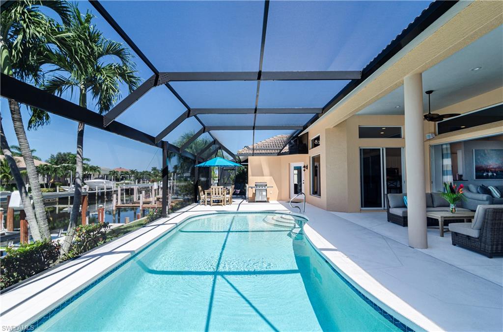 View of pool featuring a water view, a lanai, outdoor lounge area, ceiling fan, and a patio