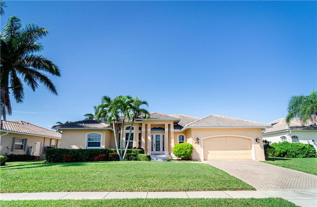 Mediterranean / spanish-style home featuring a garage, a front yard, and french doors