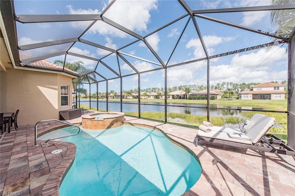 View of swimming pool with a sunroom, glass enclosure, a patio area, a residential view, and a pool with connected hot tub