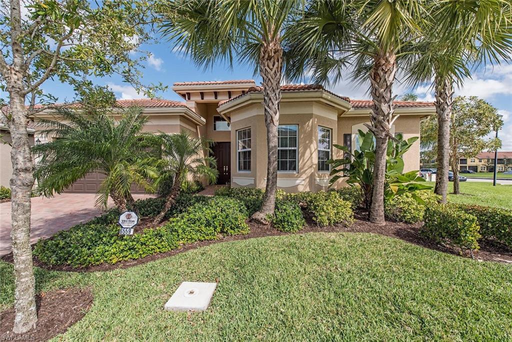 Mediterranean / spanish-style house with a front yard, stucco siding, a tiled roof, and an attached garage