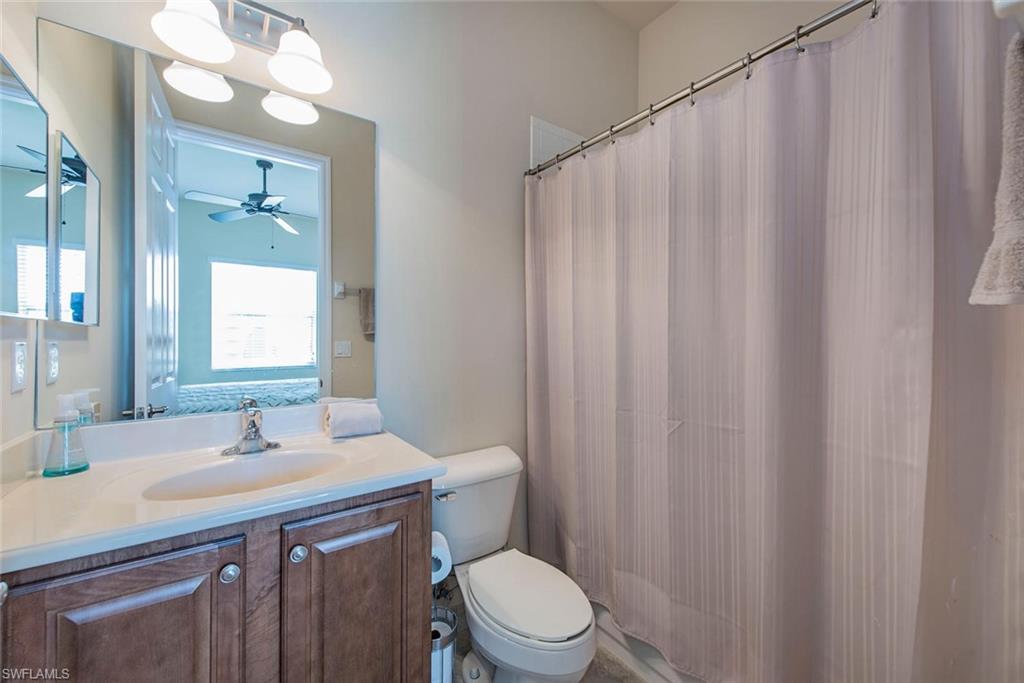 Bathroom with a shower with shower curtain, vanity, and a ceiling fan