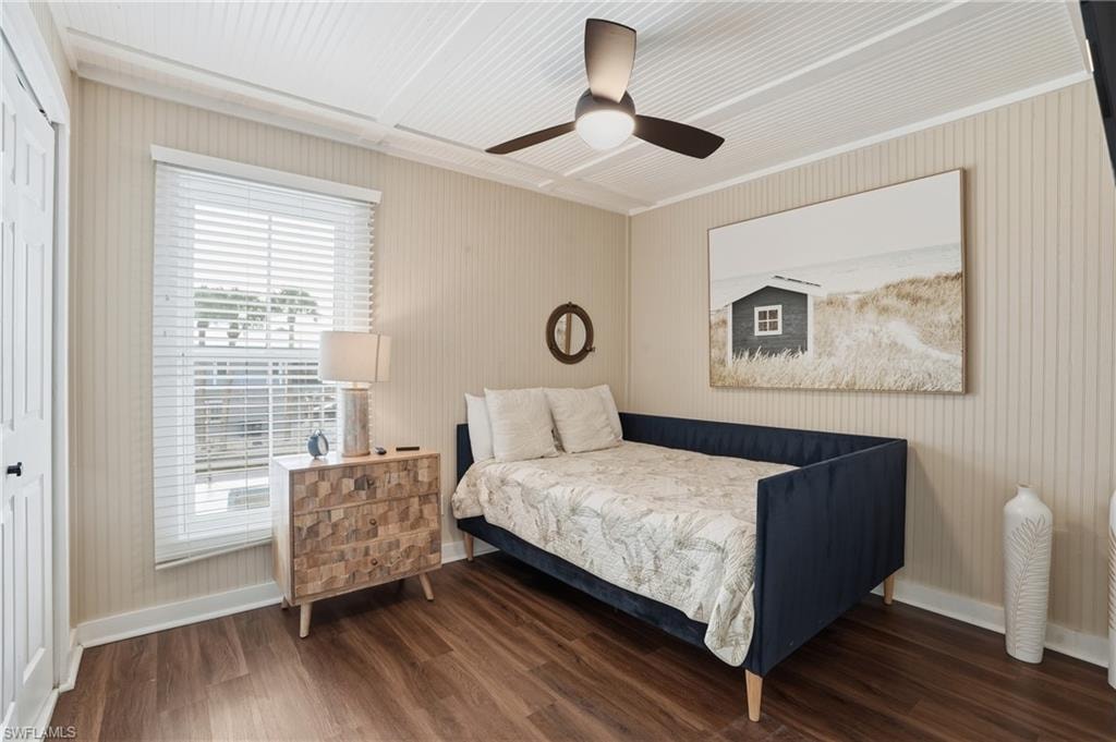 Bedroom with dark wood-style floors, a ceiling fan, and a closet - Virtually Edited Image