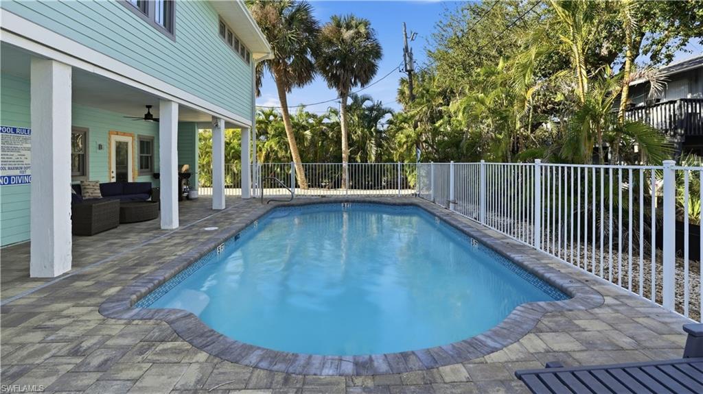 View of swimming pool featuring a patio area, a fenced backyard, and outdoor lounge area
