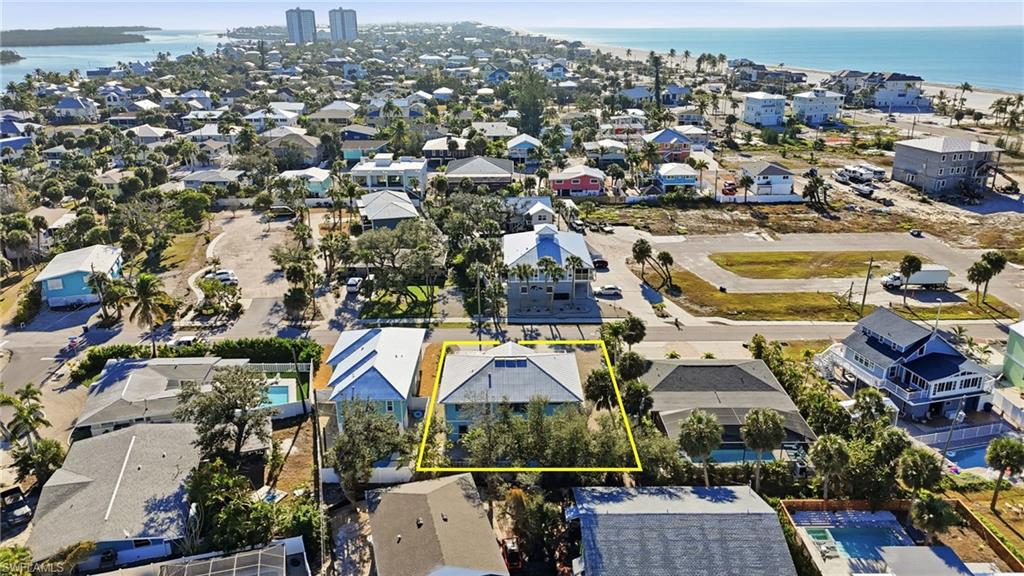 Aerial view of residential area featuring property boundaries highlighted and a nearby body of water - Virtually Edited Image