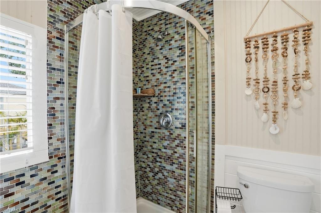 Bathroom featuring a stall shower and toilet - Virtually Edited Image