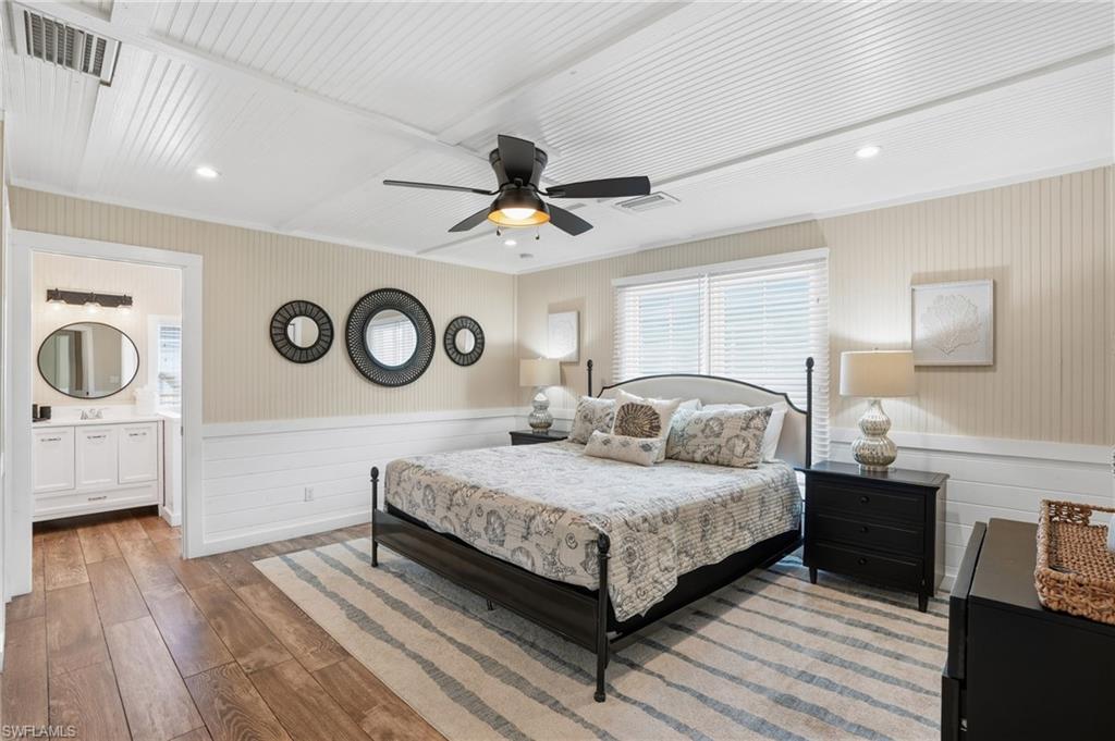 Bedroom with hardwood / wood-style flooring, a wainscoted wall, a ceiling fan, recessed lighting, and crown molding - Virtually Edited Image