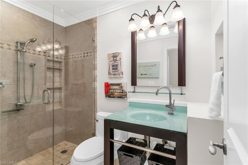 Bathroom with crown molding and a stall shower