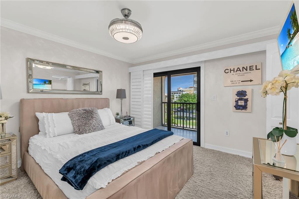 Bedroom with crown molding, light carpet, and access to outside