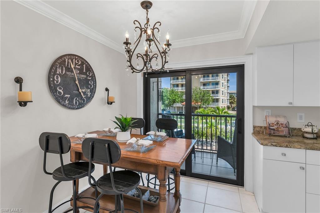 Dining space featuring ornamental molding, a chandelier, and light tile patterned flooring