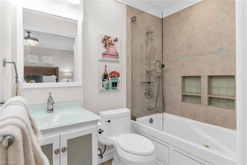 Ensuite bathroom with vanity, tub / shower combination, and crown molding