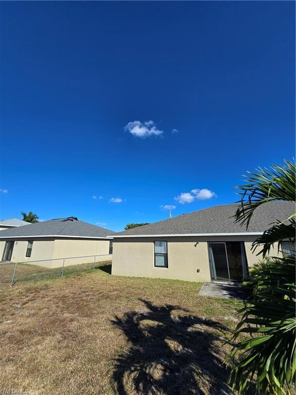 Back of property featuring stucco siding and roof with shingles