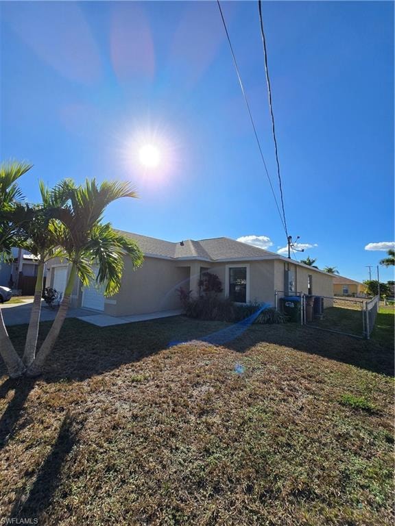 View of front of home featuring stucco siding, an attached garage, and a gate