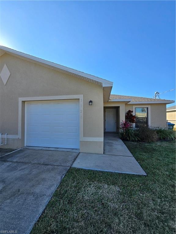 Ranch-style home with stucco siding, driveway, a front lawn, and an attached garage