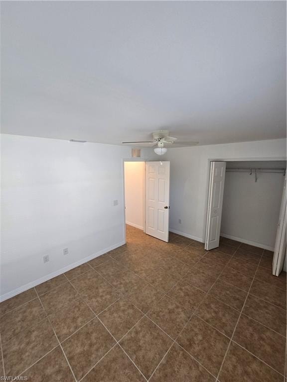 Unfurnished bedroom featuring a closet and a ceiling fan