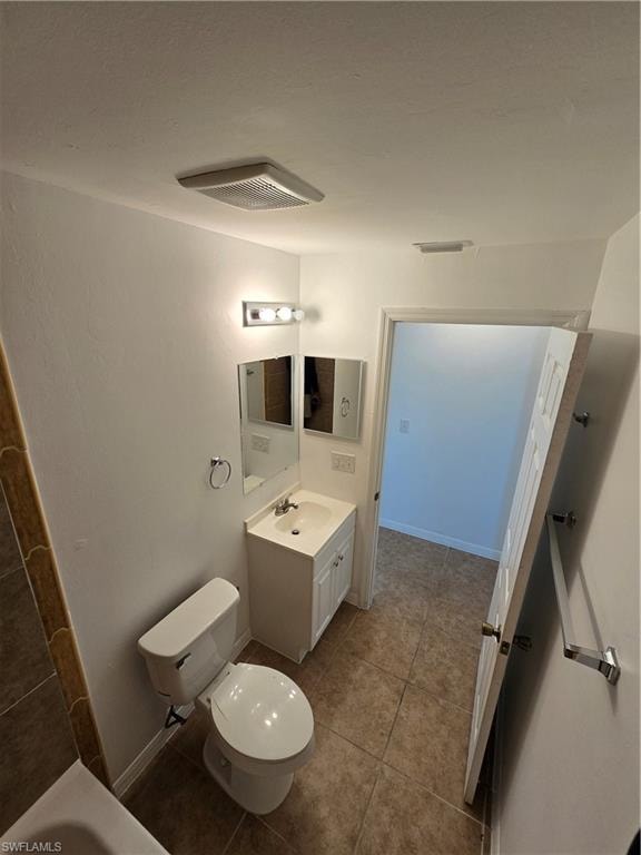 Bathroom featuring vanity, light tile patterned floors, and a tub to relax in