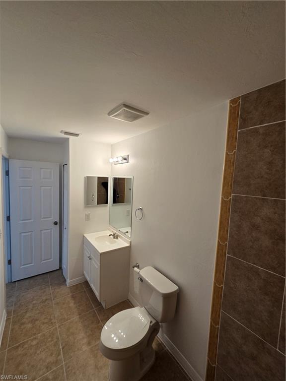 Full bathroom with vanity and dark tile patterned floors