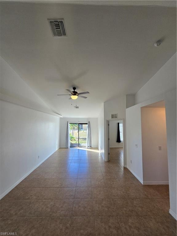 Spare room with vaulted ceiling, ceiling fan, and tile patterned flooring