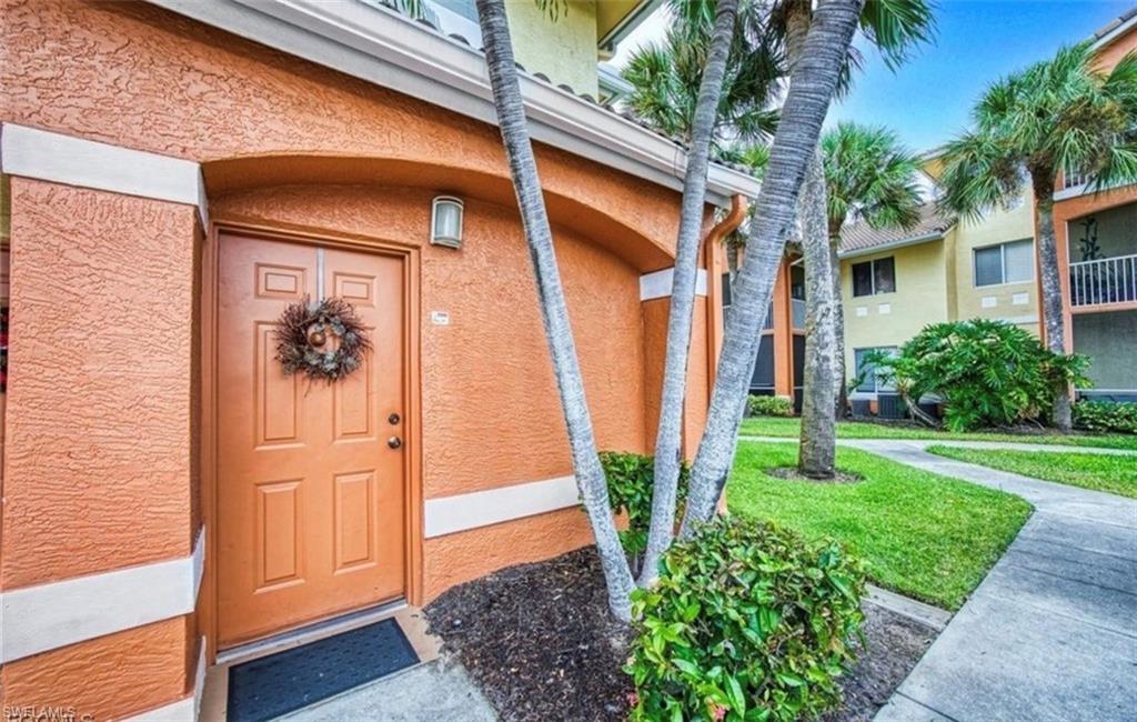 Entrance to property featuring stucco siding and a lawn