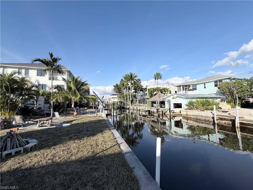 Dock featuring a water view, boat lift, and a lawn
