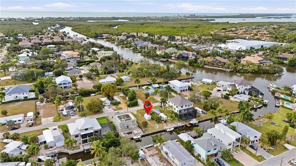 Aerial view of property and surrounding area with nearby suburban area and a large body of water