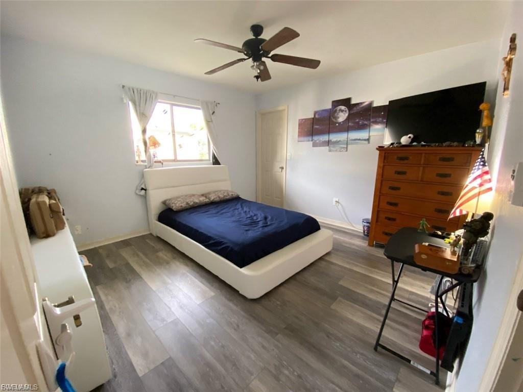 Bedroom with dark wood-type flooring and a ceiling fan