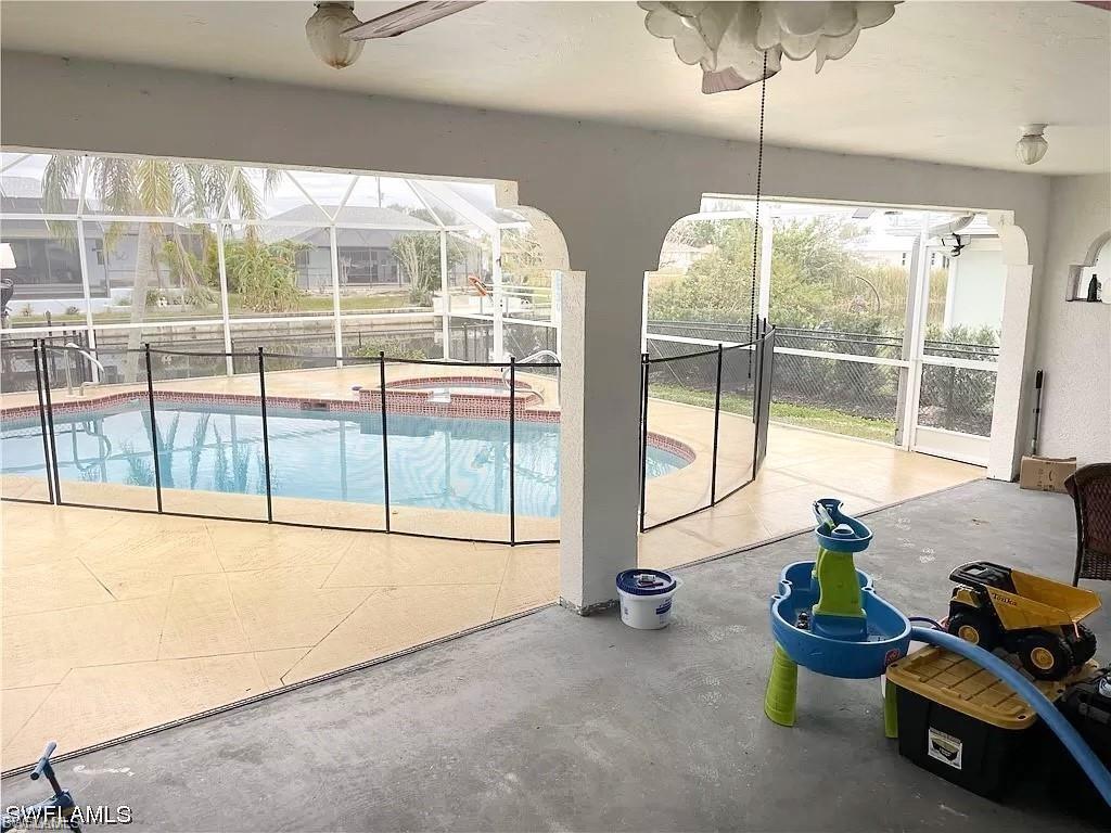 View of swimming pool with a sunroom, glass enclosure, and a patio
